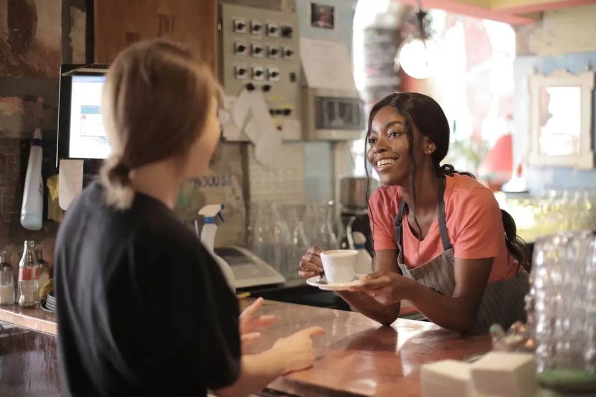 Smiling waitress wearing in cozy coffee shop
