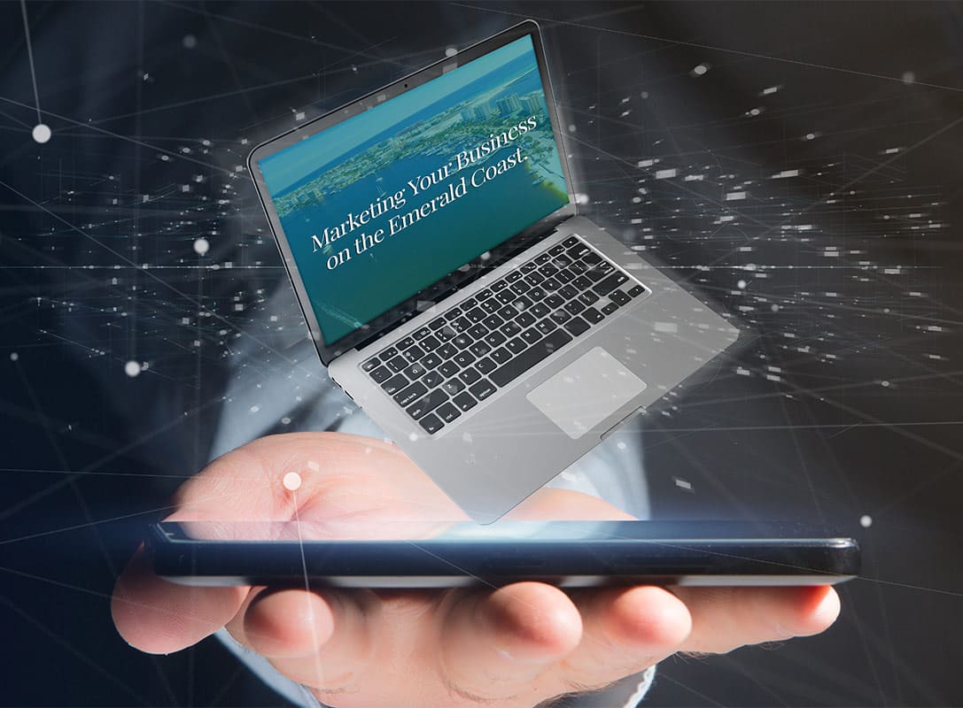 close up of hand with a cellphone in the palm with a computer tilted in top